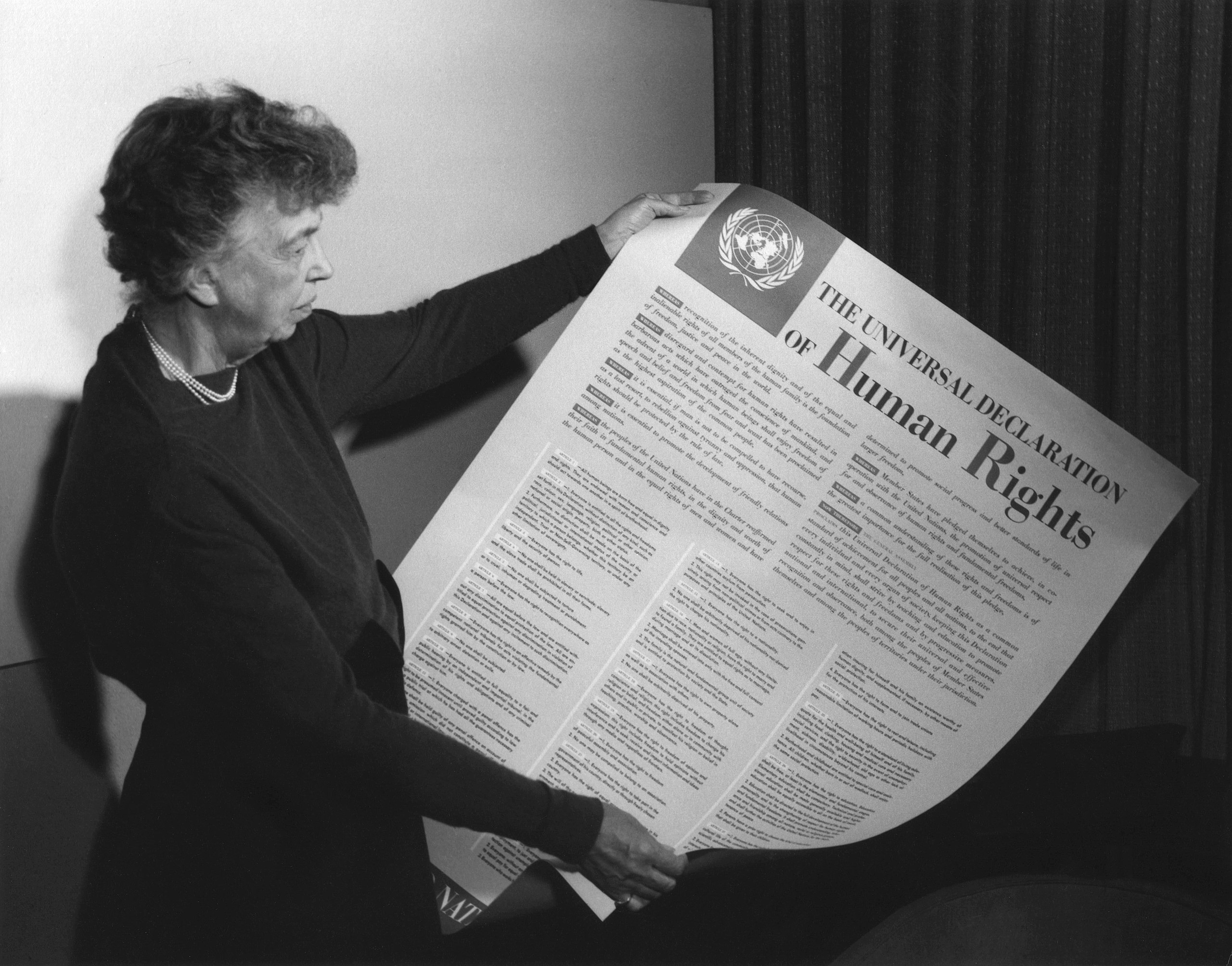 Eleanor Roosevelt, Vorsitzende der UN-Menschenrechtskommission, hält ein Poster der Erklärung der allgemeinen Menschenrechtsklärung im November 1949